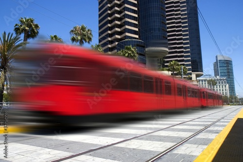 Beautiful red trolley moving fast through downtown