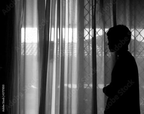 young boy waiting alone at window