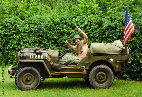 Man in military style in old fighting jeep 