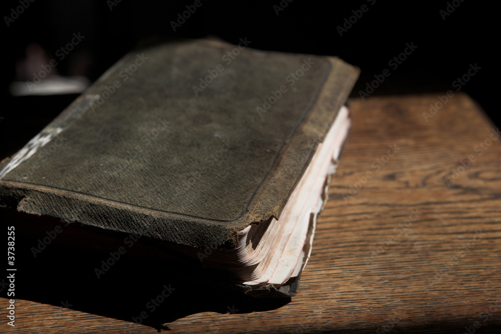 Fototapeta premium Leather covered old bible lying on a wooden table 