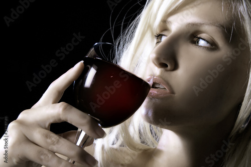 beauty blond girl is drinking wine