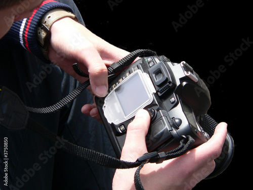 Black digital camera on hands photographer