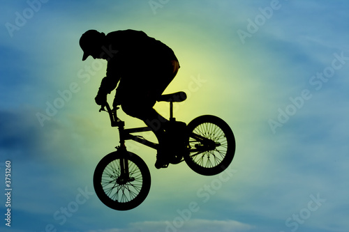 A mountainbiker flys across the sky