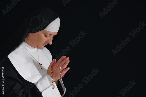 Middle aged devout nun in deep thoughts, praying.  photo