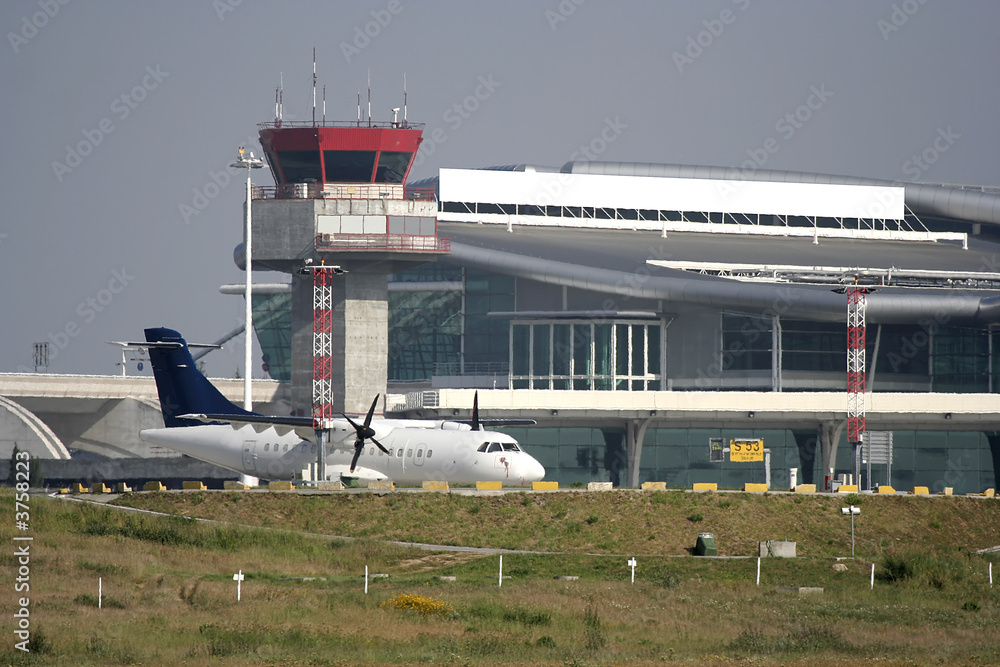 Fototapeta premium airplane parked at the airport near the tower
