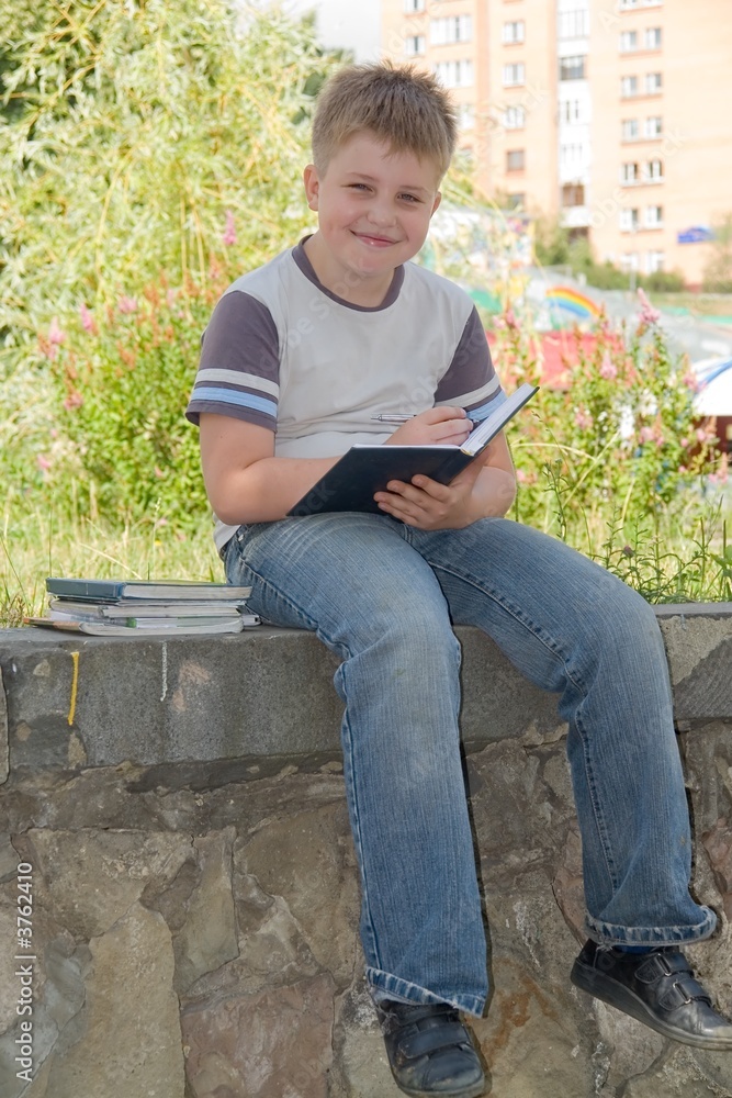 Fototapeta premium boy writes to writing-books