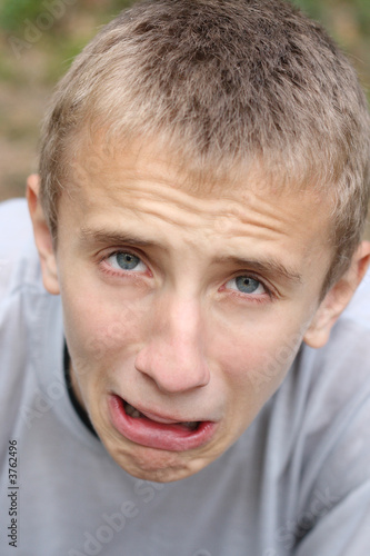 Teen-aged boy making aggrieved face photo