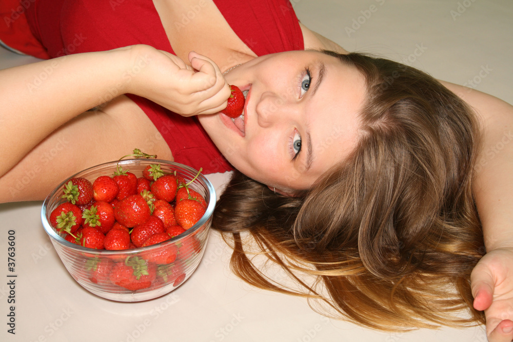 Girl holds in the hands of plate with ripe strawberry.