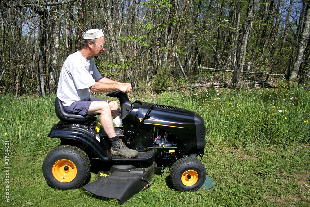 man cutting grass in a field