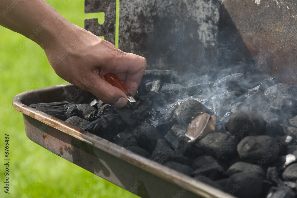 lighting the barbecue with a cigarette lighter lighting the barbecue with a cigarette lighter