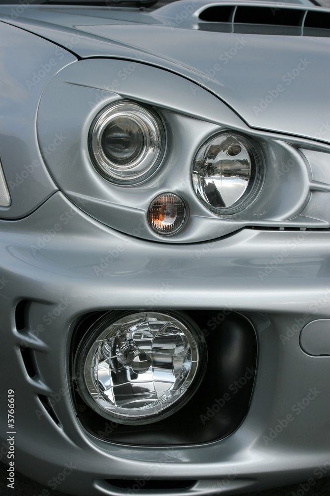 Headlights and side lights on a silver metallic car