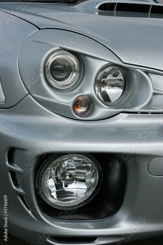 Headlights and side lights on a silver metallic car © marilyn barbone