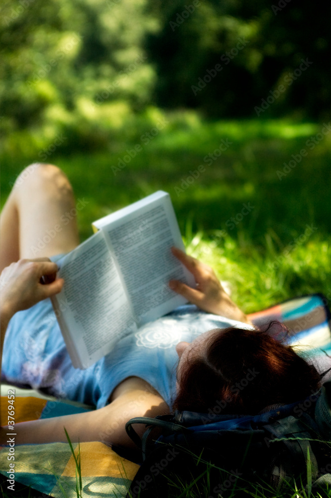 Young woman laying reading book