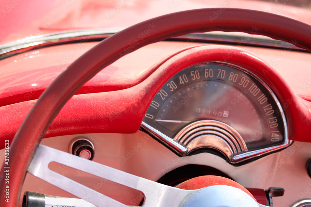 Speedometer and wheel of classic red car cloose-up