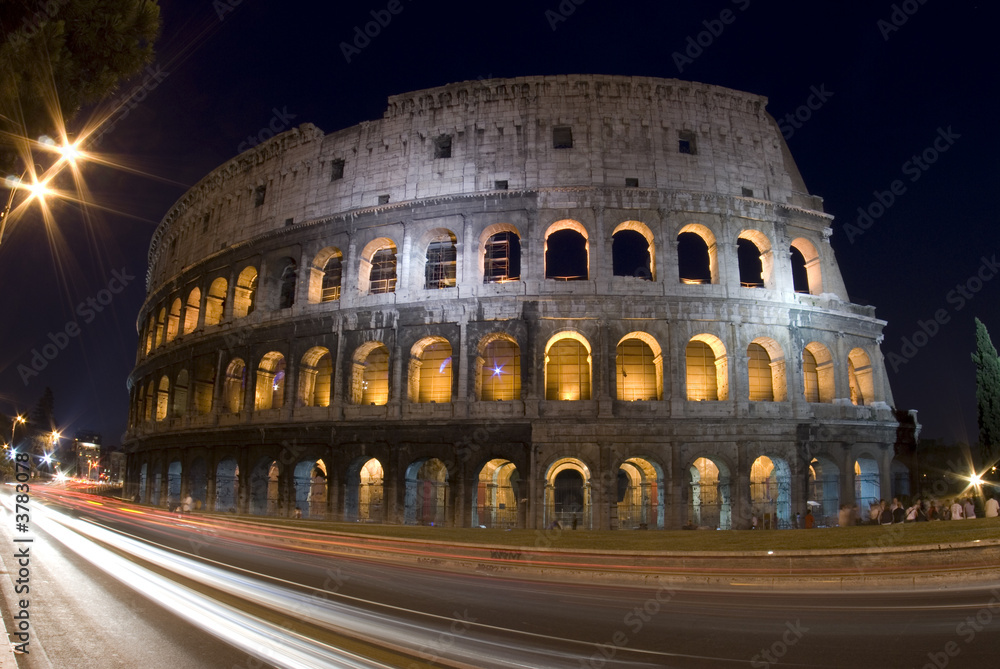 colosseum rome italy night time with car light streaks tourists
