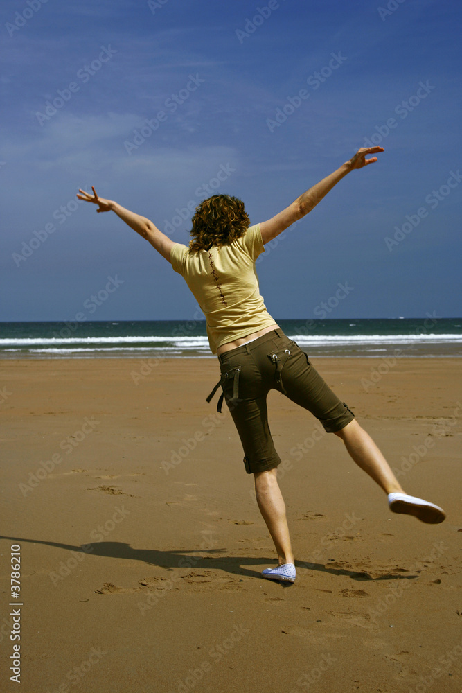 Young girl dancing happy in the beach
