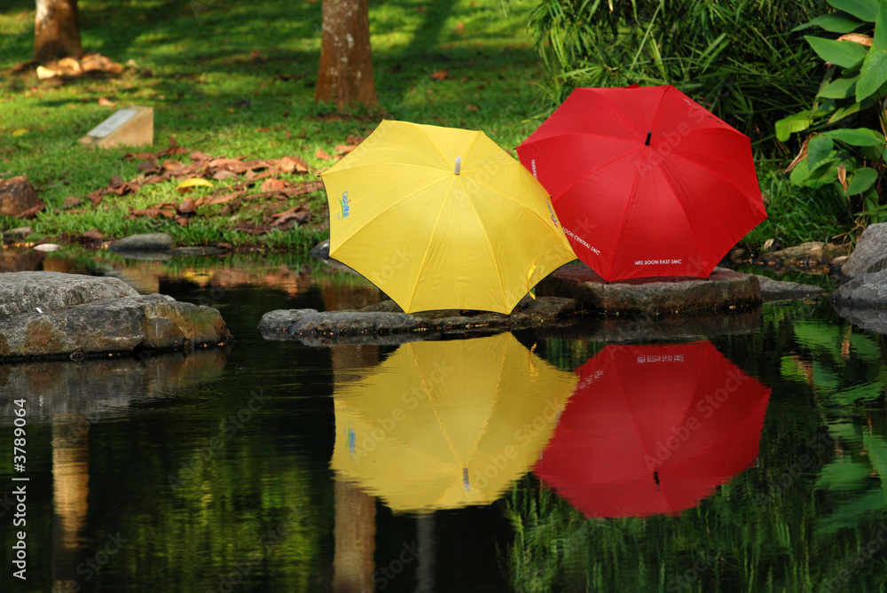 red and yellow color umbrella at the pond side