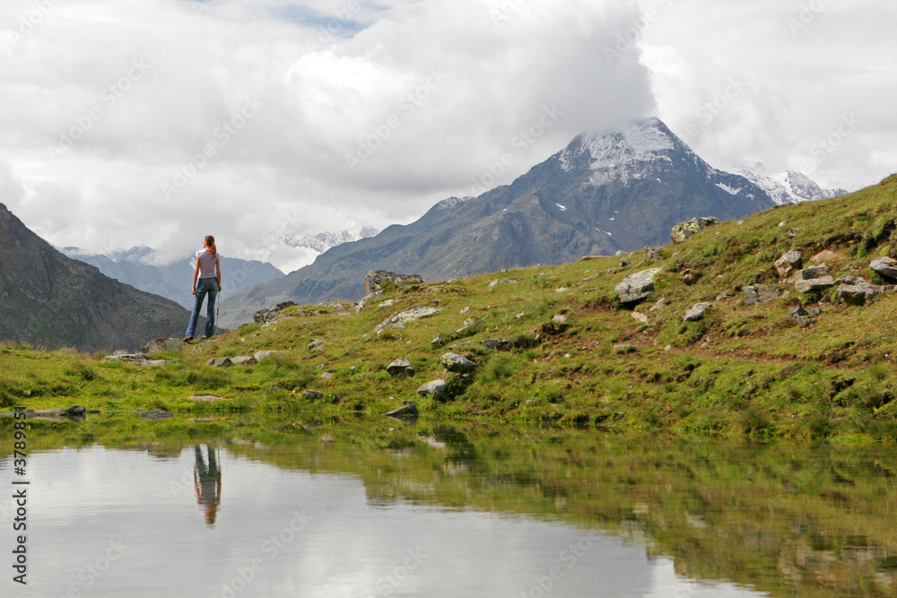 Naklejka premium Young woman hiker having a rest after long walk in mountains