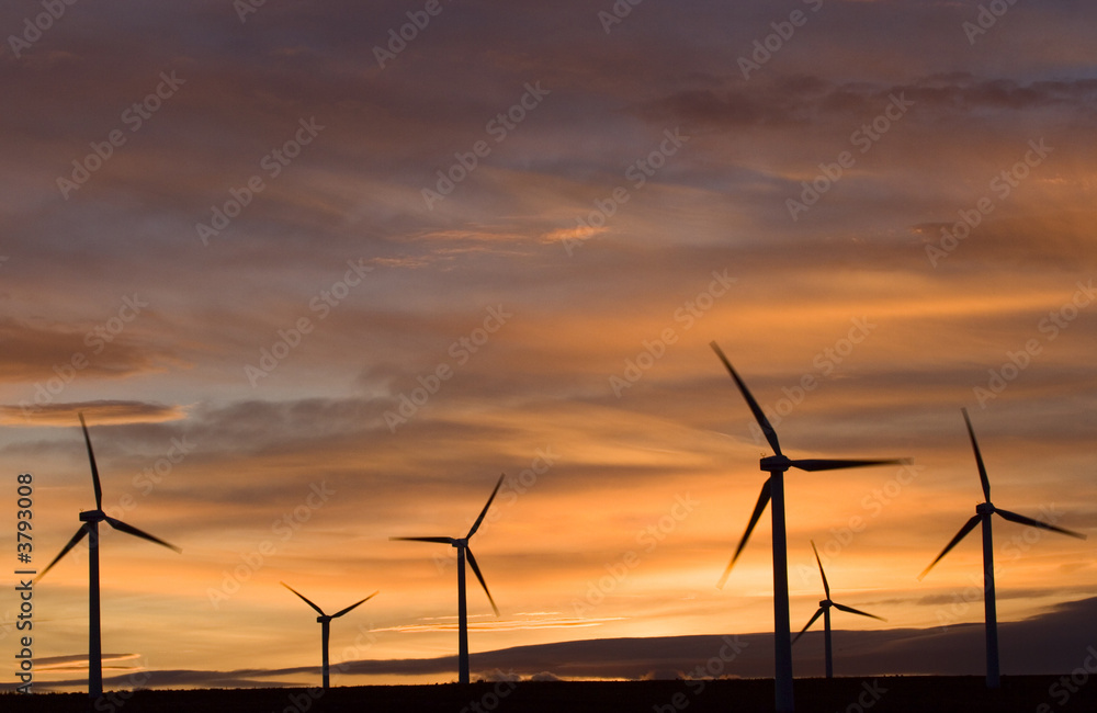 Wind turbines against an orange sunset. Wind turbines against an orange sunset.