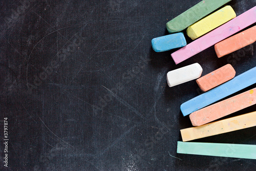 closeup of blackboard with pieces of coloured crayons