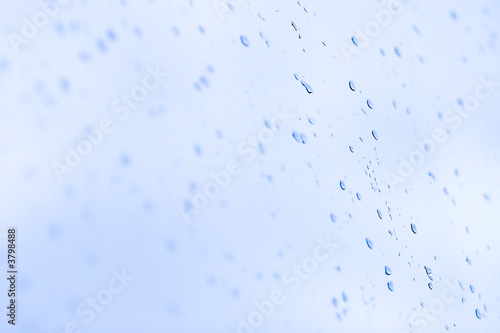 Wet drops on a glass. Blue tint and low dof.