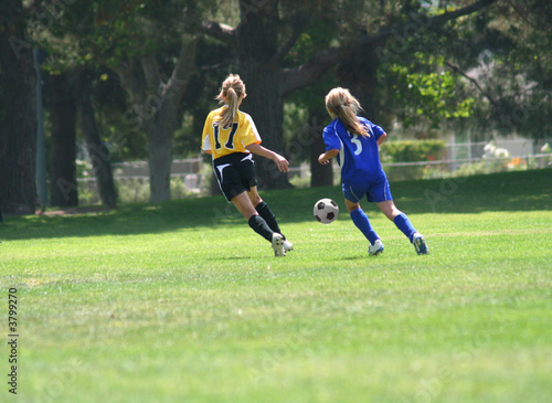 Girls chasing the ball in a soccer match