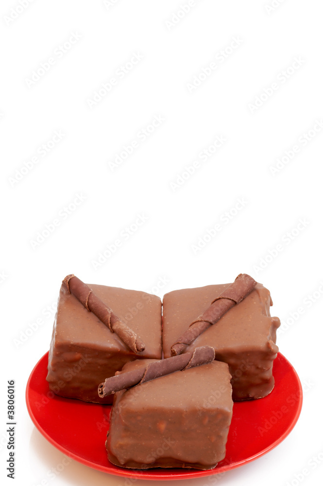 Two chocolate mini cakes on red plate, shot on white Two chocolate mini cakes on red plate, shot on white
