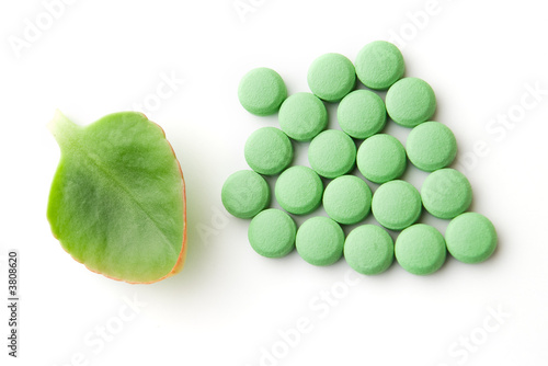 Green leaf and pills on white background photo