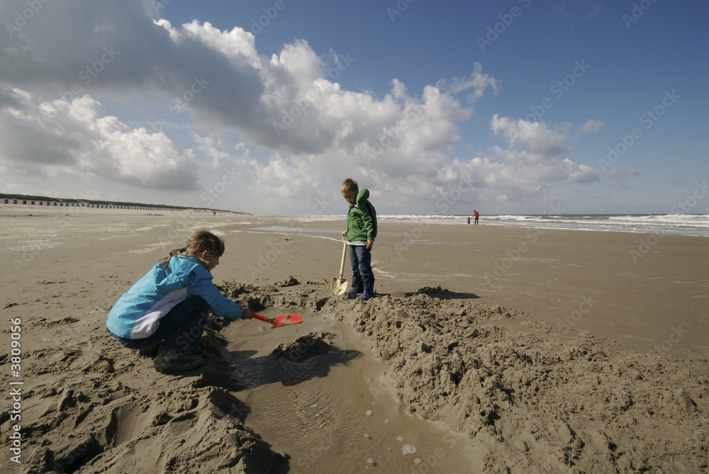 a boy and a girl playing at the beach