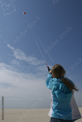 a girl flying kites at the beach
