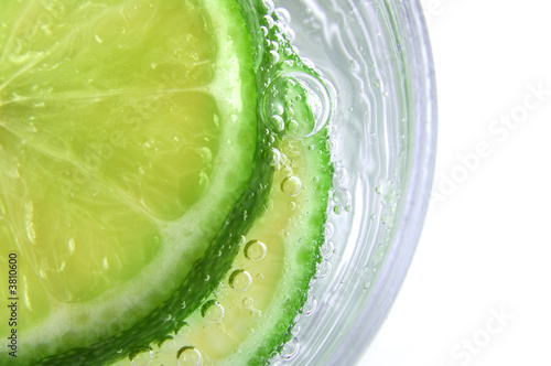 Green Lime in Soda Water with bubbles in glass