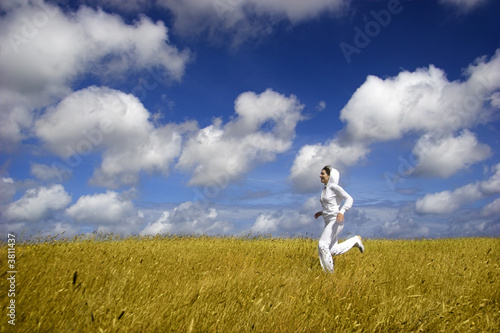 Bautiful woman running on a golden meadow