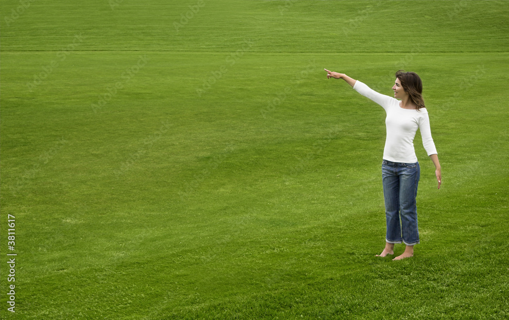 Woman on a beautiful green meadow showing something Woman on a beautiful green meadow showing something