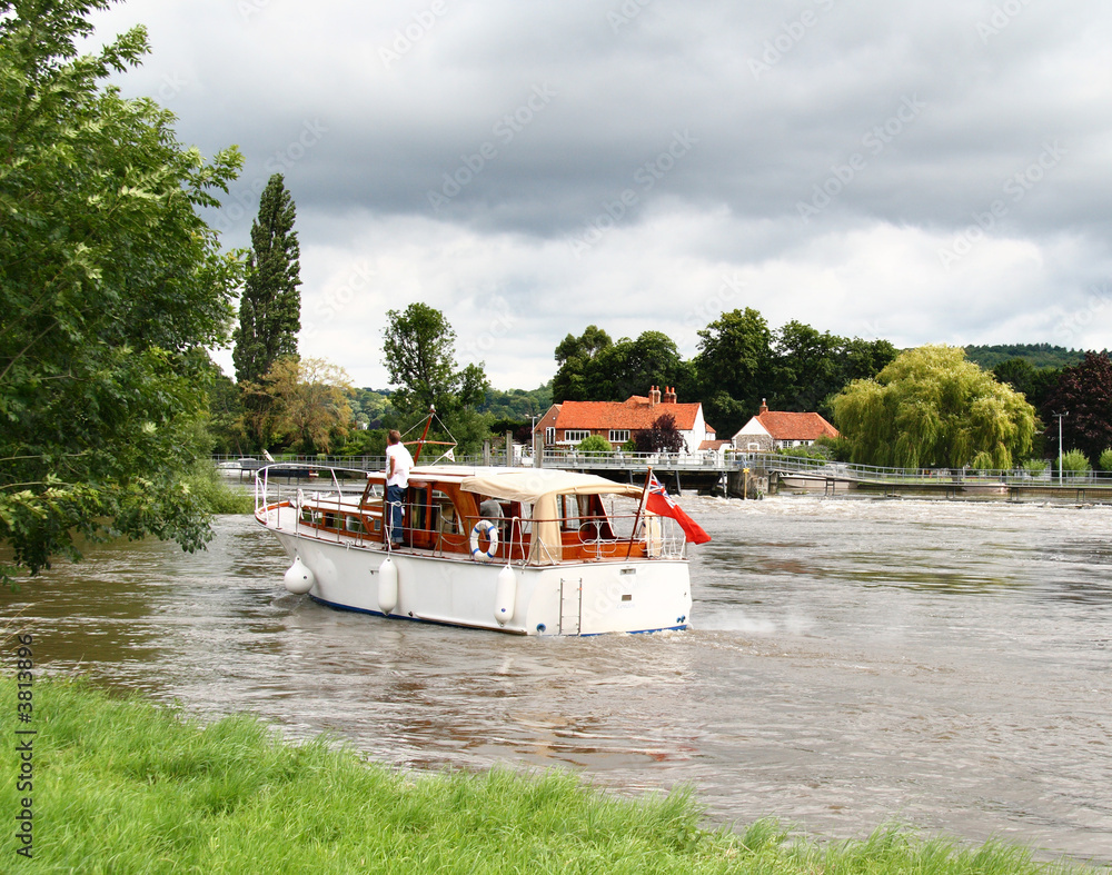 Naklejka premium Pleasure Boat on the River Thames with a Man Standng on the deck
