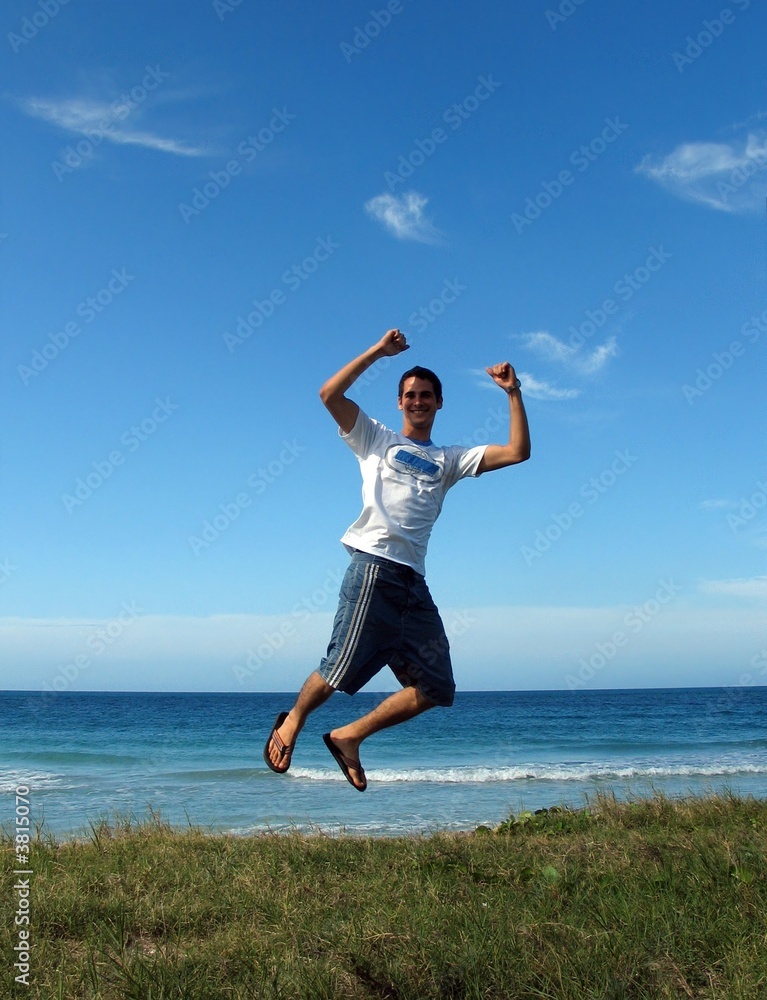 Jump for joy - Young boy jumping on air on beach background Jump for joy - Young boy jumping on air on beach background