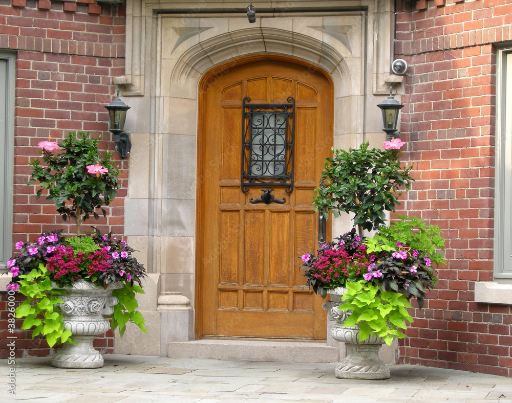 elegant house entrance with oak door and flower pots
