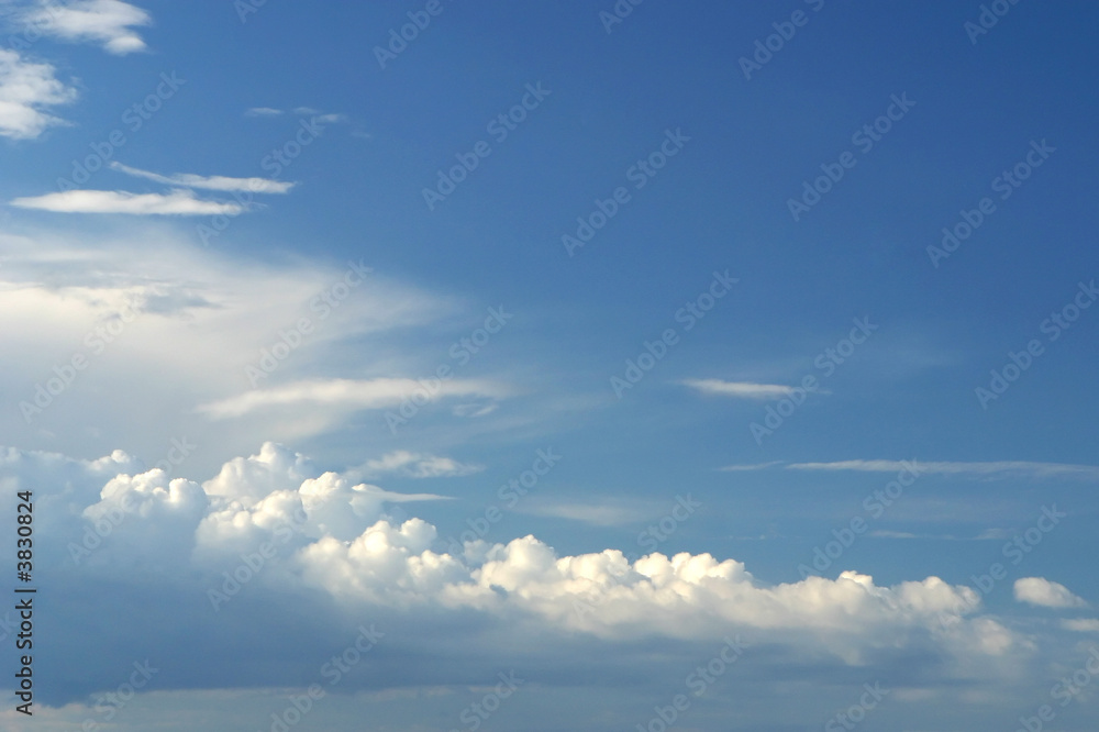 Blue sky and fluffy white clouds background.