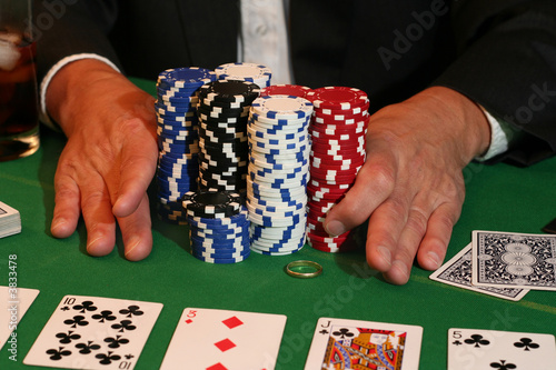 Fotografie All in! Man pushes in all his chips and his gold wedding ring.