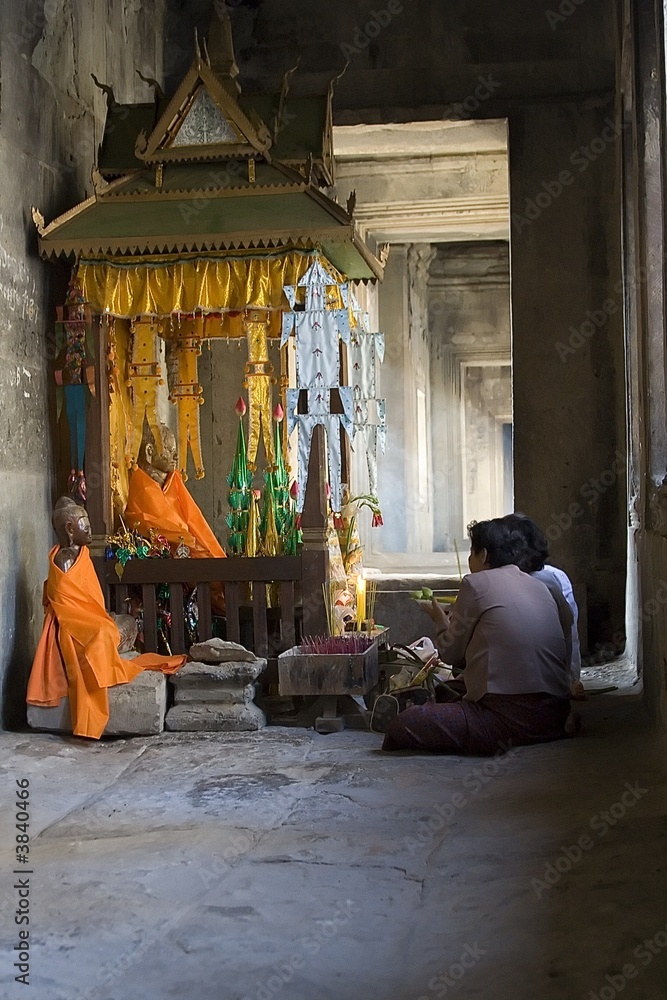 A few Poeple praying in Angor Wat corridor.