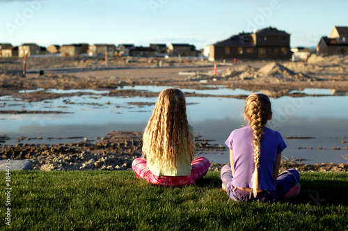Children watch as homes are built in their neighborhood.
