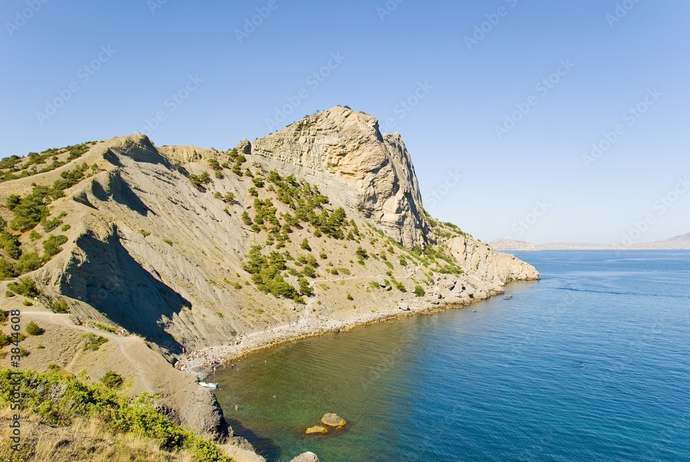 Rocky coast of the black sea. A wild beach under mountain