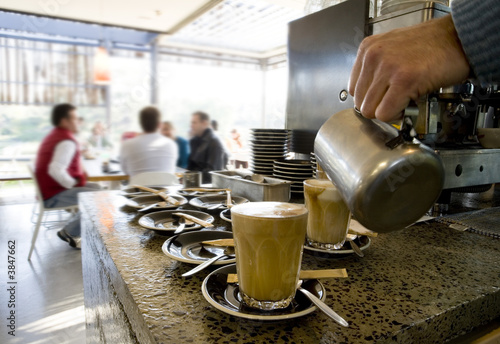 Making latte's and coffee at a cafe with people 