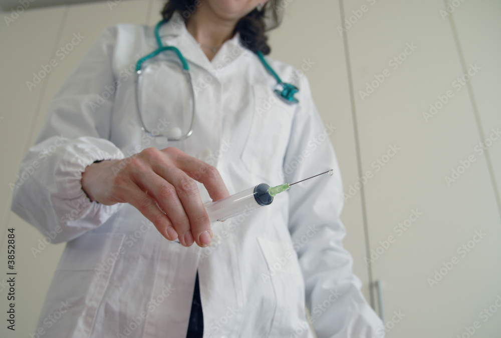 Docator holding with one hand a medical syringe Docator holding with one hand a medical syringe