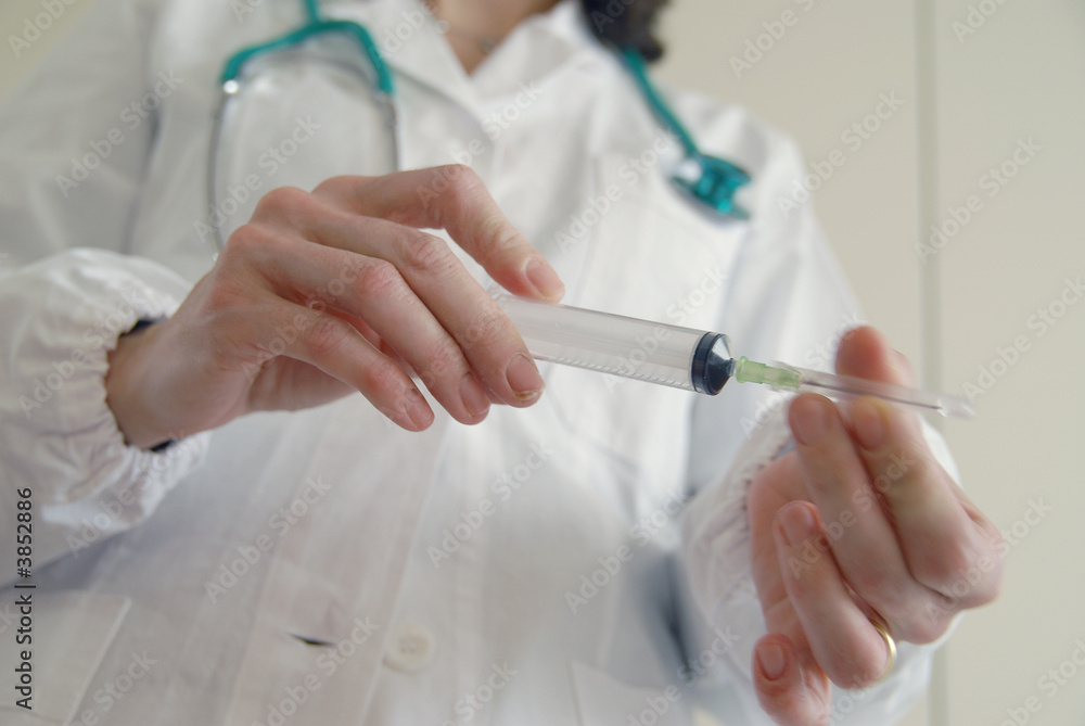 Docator holding with two hands a medical syringe Docator holding with two hands a medical syringe