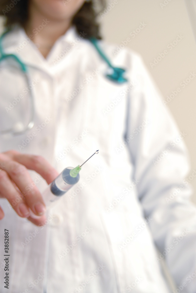 Docator holding with one hand a medical syringe Docator holding with one hand a medical syringe