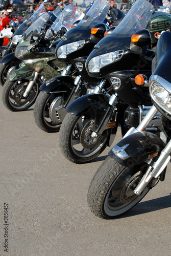 Motorcycles stand in a line on road