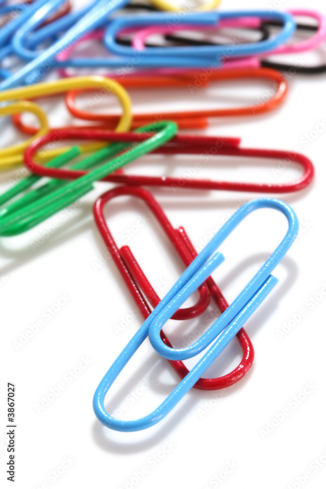 Colorful paperclips, scattered on white background 