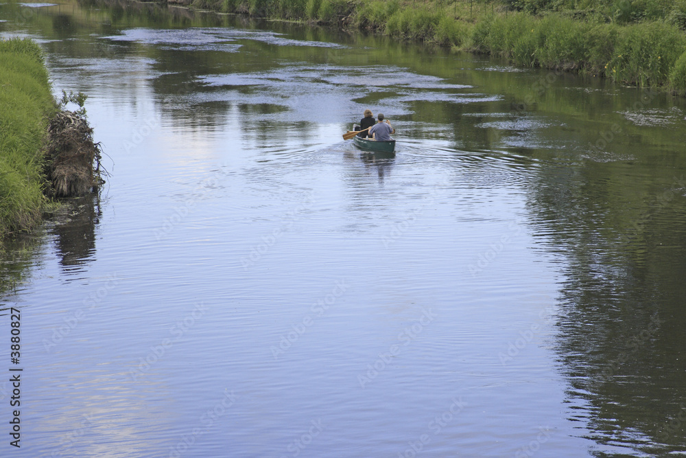 People taking the canoe down the river on a lazy day People taking the canoe down the river on a lazy day