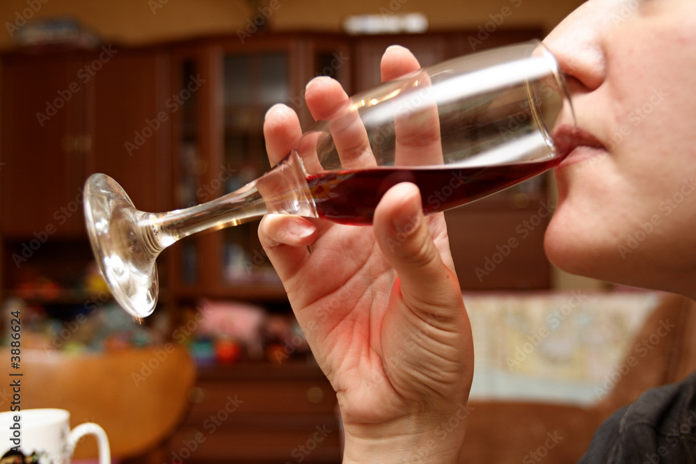 Obraz premium The girl drinks red wine at home