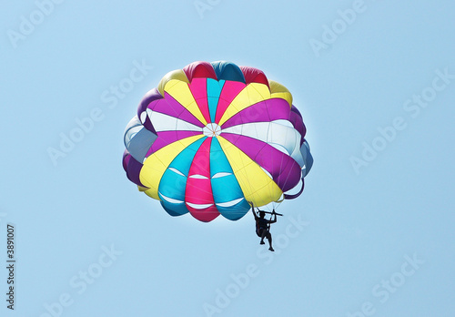 Multi coloured parachute over the blue sky